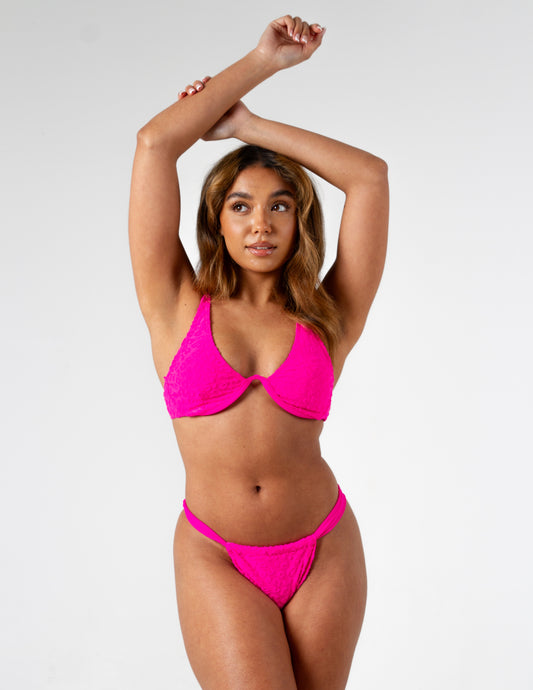 Neon pink leopard print textured padded boned bikini top with adjustable straps on gorgeous model - front