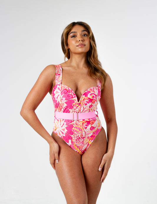 Figure-enhancing pink printed swimsuit with waist-cinching belt and sweetheart v neck padded cup design on our beautiful model. Front side