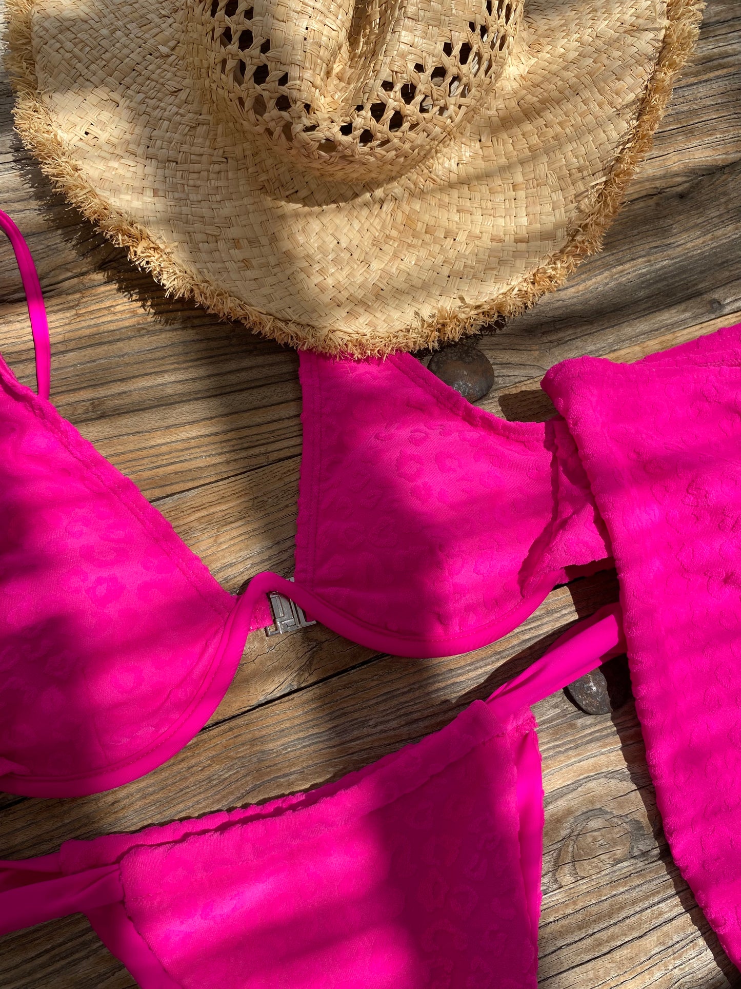 Neon pink leopard print textured bikini bottoms with medium adjustable coverage - flat lay